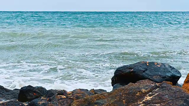 强烈的海浪拍打着布满岩石的海滩视频素材