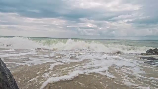 强烈的海浪拍打着布满岩石的海滩视频素材