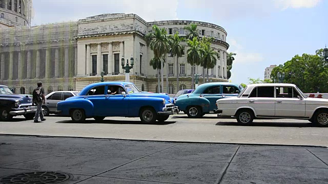 古巴哈瓦那:在El Capitolio建筑前，各种各样的汽车视频素材