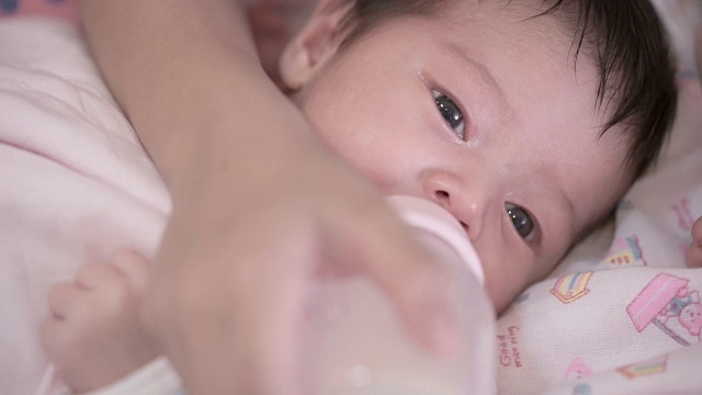 母亲用奶瓶喂亚洲新生女婴视频素材