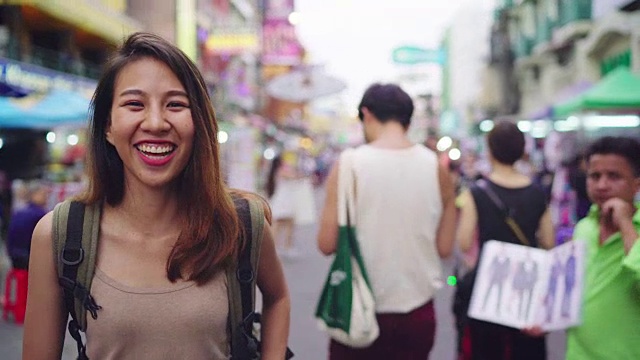 旅行家背包亚洲女人旅行在考山路在曼谷，泰国。快乐的年轻女性在惊人的地标假日旅行，享受她的旅程在传统城市。视频素材