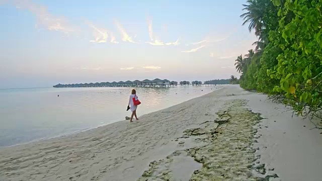 女士走在田园诗般的热带海洋海滩上，马尔代夫视频素材