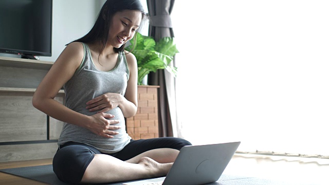 年轻孕妇在家使用笔记本电脑视频素材