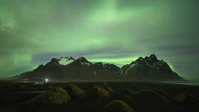 冰岛的夜景:斯托克尼斯的vestrahorn山，黑色沙丘，令人惊叹的北极光(上下移动)视频下载