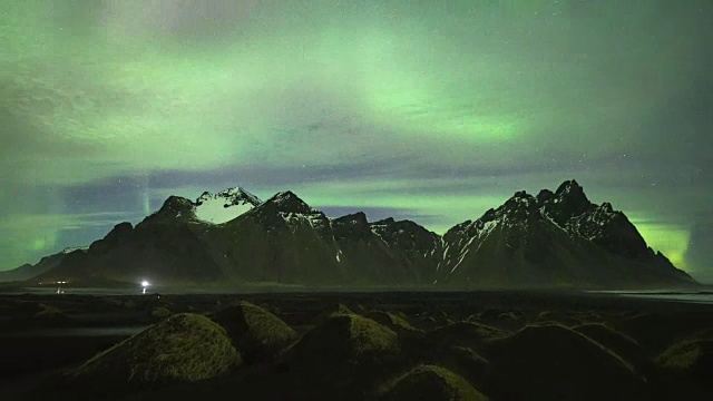 冰岛的夜景:斯托克尼斯的vestrahorn山，黑色沙丘，令人惊叹的北极光(放大)视频下载