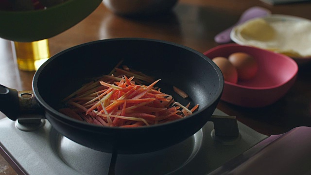 准备食物-把切碎的胡萝卜放入平底锅，4k视频素材