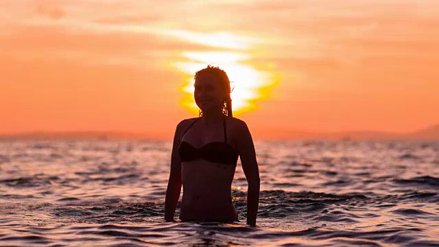 日落时分，女人在海里甩发视频素材