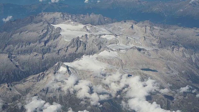 在夏季飞过阿达梅洛·普雷斯内拉阿尔卑斯山。冰川的景观。从飞机窗口鸟瞰图视频素材