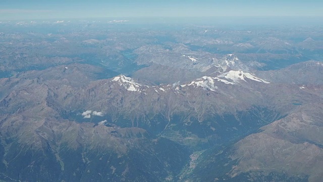 在夏季飞越欧洲阿尔卑斯山。冰川的景观。从飞机窗口鸟瞰图视频素材