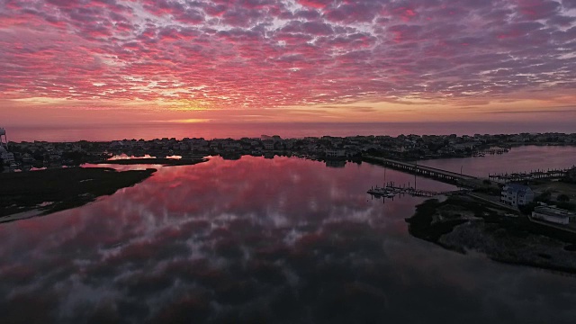 无人机在Wrightsville海滩壮观的粉红色日出期间，豪华海滩房屋的上升鸟瞰图视频素材