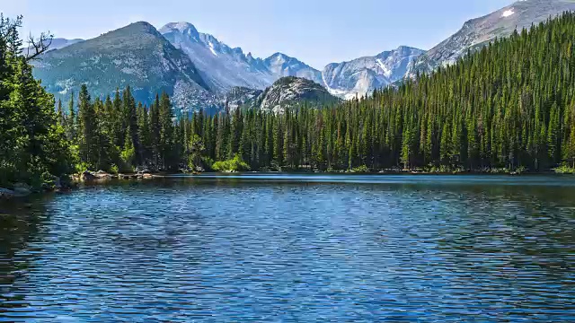 熊湖-大风搅动平静的熊湖在一个阳光明媚的夏天早晨，崎岖的朗斯峰和冰川峡谷高耸的背景，落基山国家公园，CO，美国。视频素材