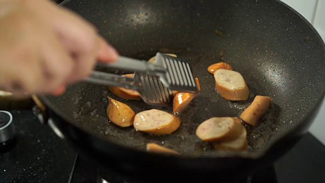 慢动作的猪肉香肠切片在煎锅里煮视频素材