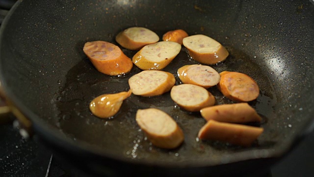 慢动作的猪肉香肠切片在煎锅里煮视频素材