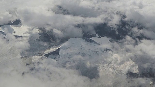 在夏季飞越欧洲阿尔卑斯山。冰川的景观。从飞机窗口鸟瞰图视频素材