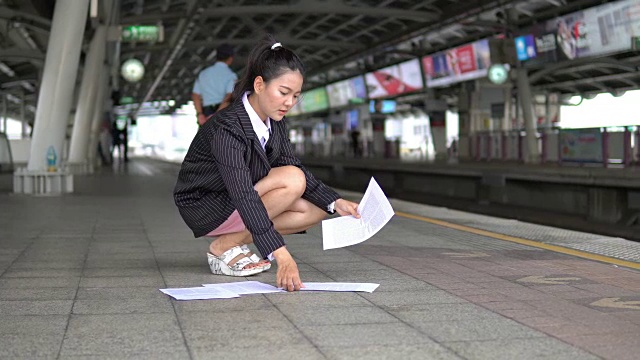 亚洲女商人在等待火车到达时打电话。视频素材