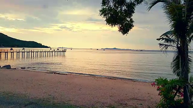 舒适的海滩和沙滩，夕阳下金色的天空视频素材