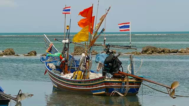 热带海洋海滩景观用传统的木制小渔船系泊。泰国苏梅岛亚洲贫穷的穆斯林渔村附近的海景。船上有旗子和灯。视频素材