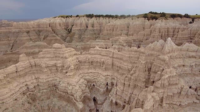 无人机史诗鸟瞰图的Badlands编队飞回通过高岩石山峰和陡峭的峡谷视频素材