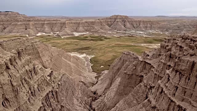 无人机鸟瞰图之间的高Badlands岩石形成宁静的绿色山谷视频素材