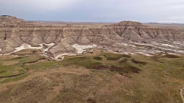 无人机史诗般的高海拔鸟瞰Badlands山谷的史前岩层在白天视频素材