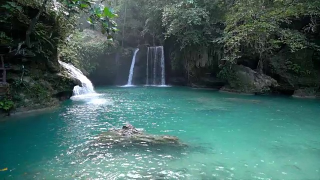 在菲律宾的宿务岛，一个年轻的女人凝视着美丽的瀑布。人们旅行热爱自然的理念。一个人只喜欢在一个宁静的环境里享受户外的宁静视频素材