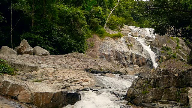 神奇的热带雨林和河流与岩石的风景。野生植被，深热带森林。丛林里的树木和湍急的岩石溪流。蒸汽和石头瀑布流过异国的树林。视频素材