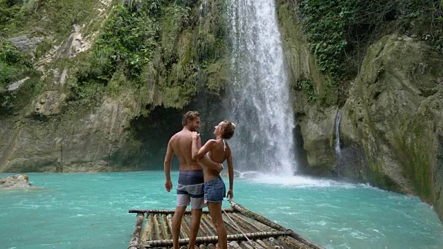 年轻夫妇在菲律宾美丽的热带瀑布深情享受假期和自由。人们旅行的爱情概念视频素材