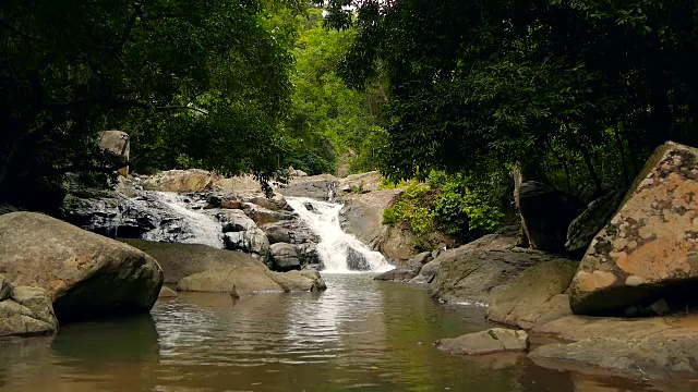 神奇的热带雨林和河流与岩石的风景。野生植被，深热带森林。丛林里的树木和湍急的岩石溪流。蒸汽和石头瀑布流过异国的树林。视频素材