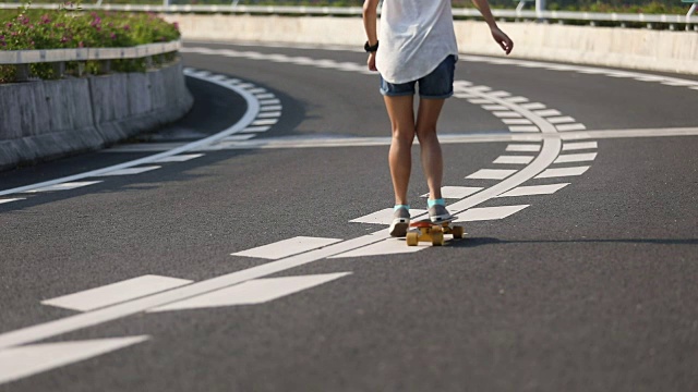 在高速公路上玩滑板的女人视频素材