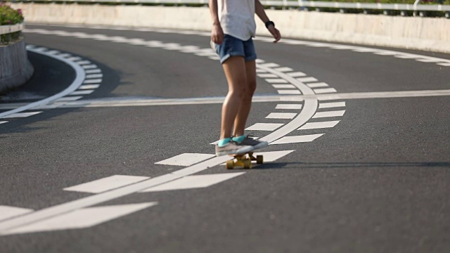 女子在高速公路上玩滑板，慢镜头视频素材