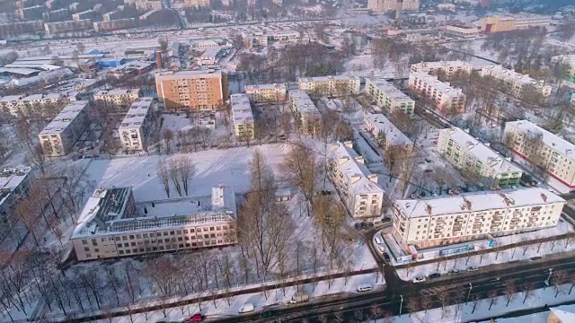 在晴朗寒冷的日子里，鸟瞰被雪覆盖的冬季城市全景视频素材