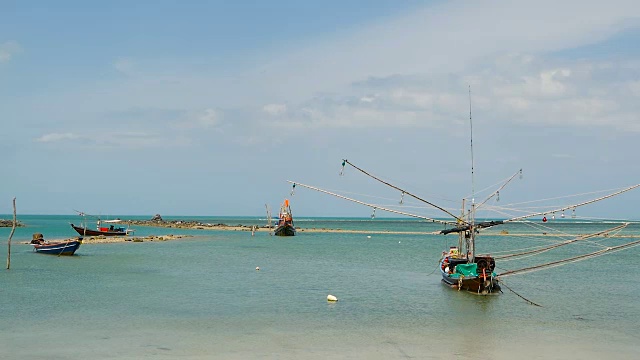 热带海洋海滩景观用传统的木制小渔船系泊。泰国苏梅岛亚洲贫穷的穆斯林渔村附近的海景。船上有旗子和灯。视频素材