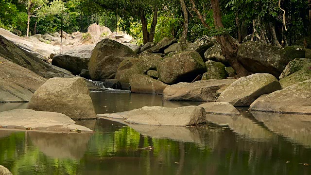 神奇的热带雨林和河流与岩石的风景。野生植被，深热带森林。丛林里的树木和湍急的岩石溪流。蒸汽和石头瀑布流过异国的树林。视频素材