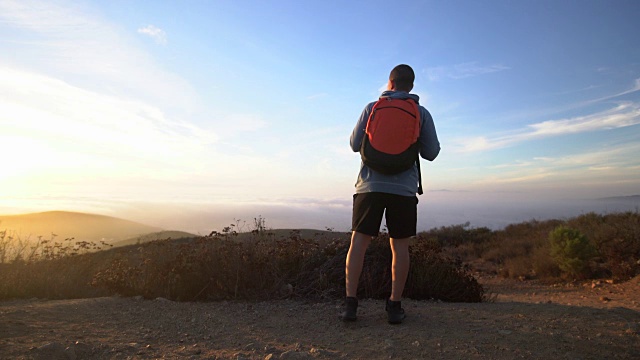 一个年轻人在山里徒步旅行视频素材