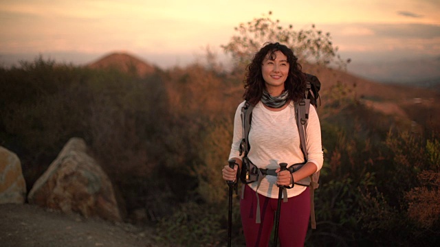 一位年轻的亚洲妇女在山里徒步旅行视频素材