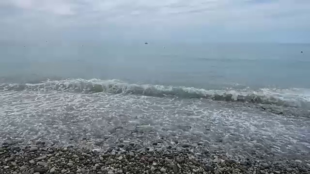 海景-海浪和泡沫拍在卵石上视频素材