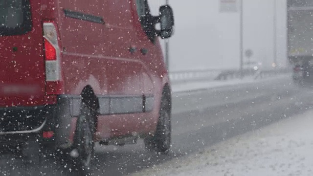 慢镜头:冬天，卡车和货车在危险的雪地公路上行驶视频素材