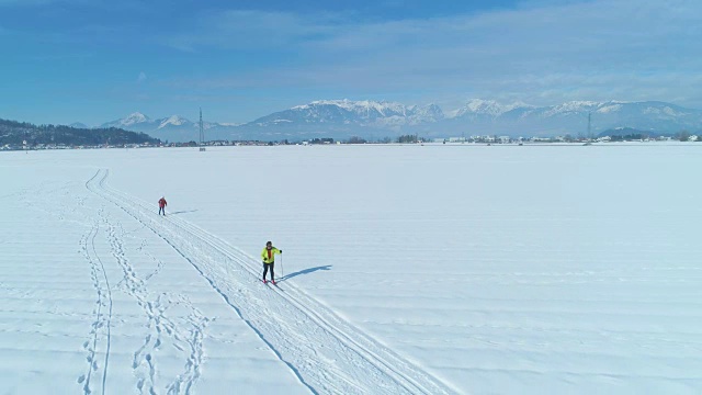 航拍:两个陌生的女游客正在越野滑雪视频素材