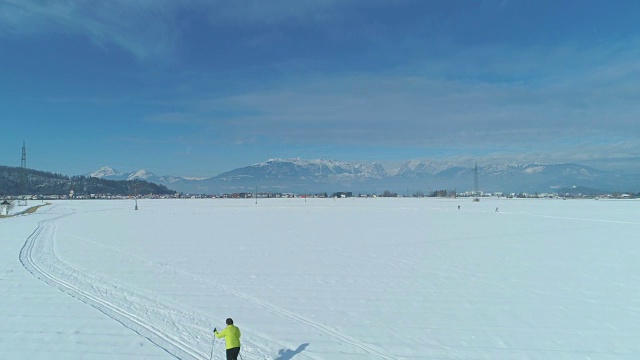 航拍图:阳光明媚的一天，两名活跃的女性游客正在滑雪视频素材