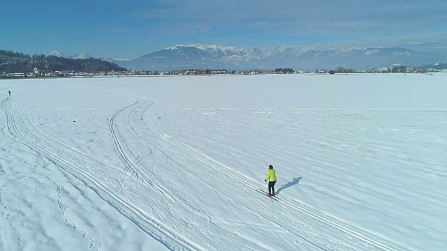 在白雪中滑雪的女人后面飞行。视频素材