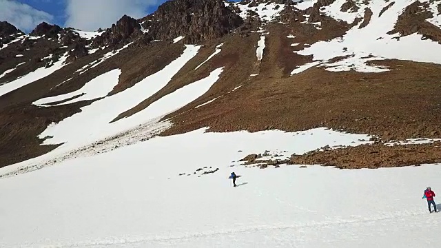 鸟瞰图两个徒步旅行者在雪山之间视频素材