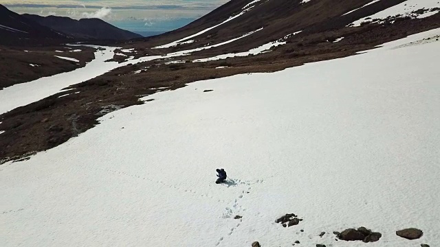 鸟瞰图远足者落在雪山之间视频素材