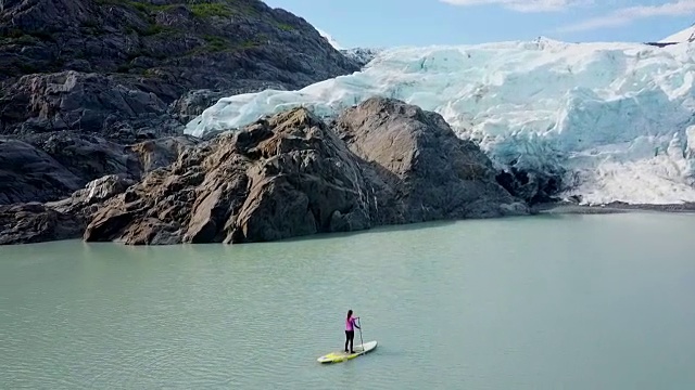 鸟瞰图的冰川和妇女在SUP在海湾视频素材