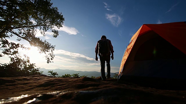 一名亚洲徒步旅行者站在喀尔巴阡山脉的露营帐篷附近。游客在泰国欣赏山景。视频下载