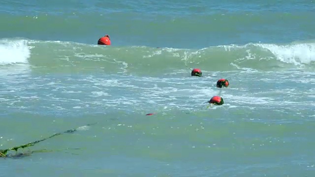 封闭的红色浮标漂浮在海上的波浪上视频素材