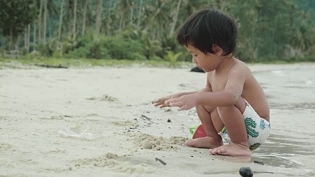 亚洲小男孩在沙滩上玩沙堡视频素材