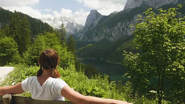 奥地利戈索泽，一名年轻女子坐在长凳上欣赏风景视频素材