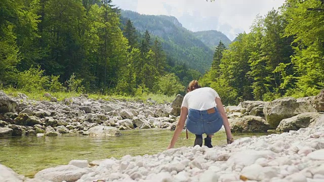 奥地利萨尔茨堡，一名年轻女子在检查山河中的水视频素材