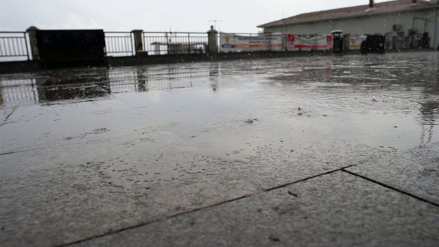 慢镜头雨点落在地上，模糊了背景，外面，阴天视频素材