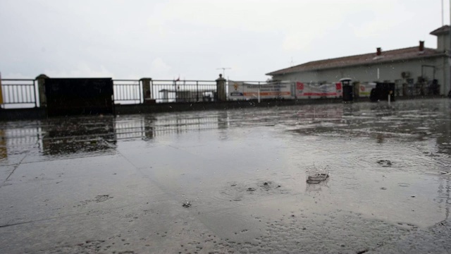 慢镜头雨点落在地上，模糊了背景，外面，阴天视频素材